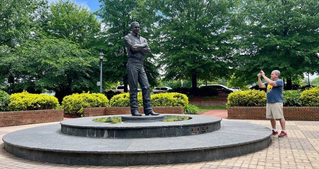 A fan takes a cell-phone photo of the Dale Earnhardt statue in the center of the tribute plaza in Kannapolis, North Carolina.