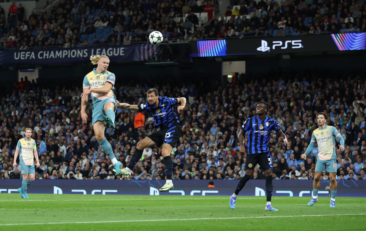 MANCHESTER, ENGLAND - SEPTEMBER 18: Erling Haaland of Manchester City heads the ball under pressure from during the UEFA Champions League 2024/25 League Phase MD1 match between Manchester City and FC Internazionale Milano at City of Manchester Stadium on September 18, 2024 in Manchester, England. (Photo by Carl Recine/Getty Images)