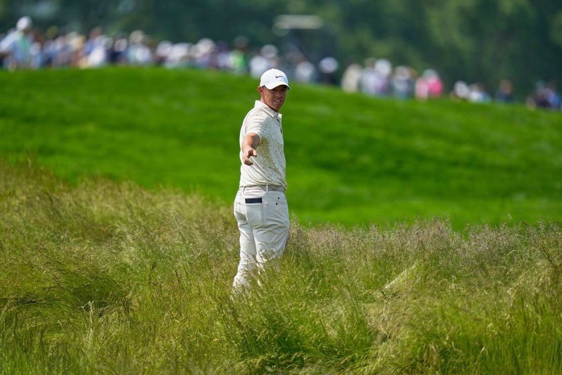 Rory McIlroy, of Northern Ireland, prepares to hit from the tall grass on the fourth hole during the first round.