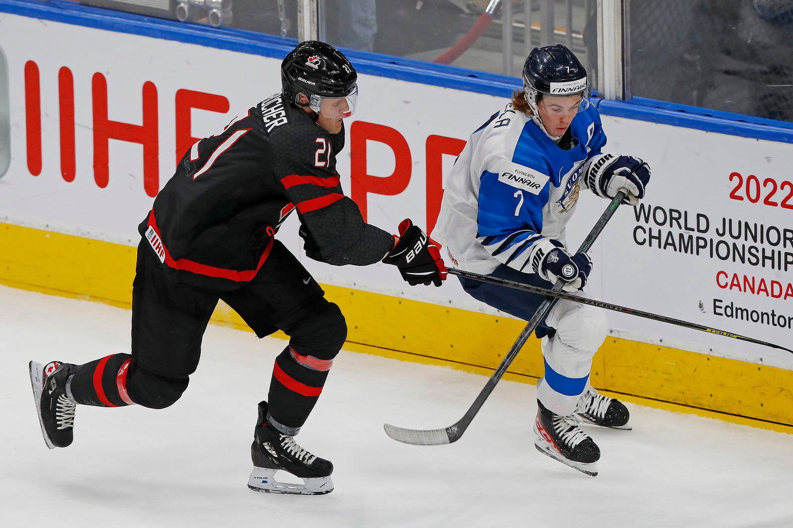 Aug 20, 2022; Edmonton, Alberta, CAN; Team Canada forward Nathan Gaucher (21) and Team Finland defensemen Topi Niemela (7) chase a loose puck during the first period in the championship game during the IIHF U20 Ice Hockey World Championship at Rogers Place. Mandatory Credit: Perry Nelson-Imagn Images
