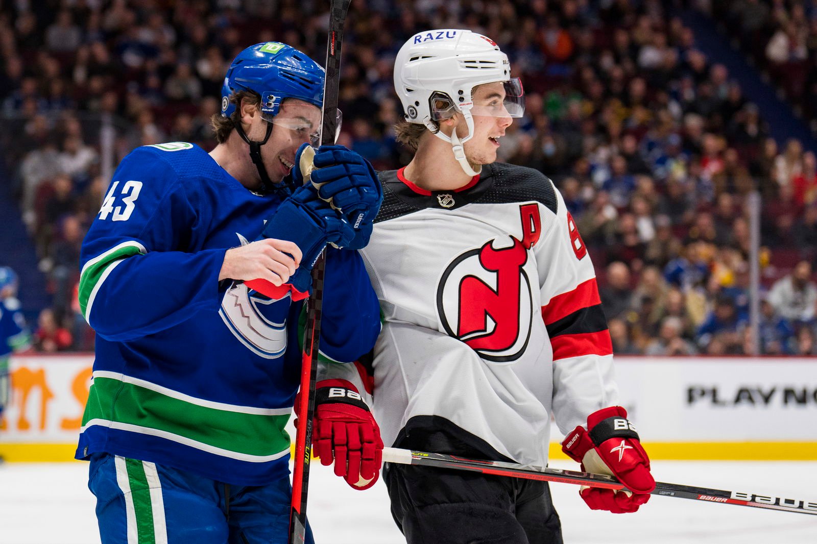 Mar 15, 2022; Vancouver, British Columbia, CAN; Vancouver Canucks defenseman Quinn Hughes (43) shares laugh with his brother New Jersey Devils forward Jack Hughes (86) in the second period at Rogers Arena. Mandatory Credit: Bob Frid-Imagn Images