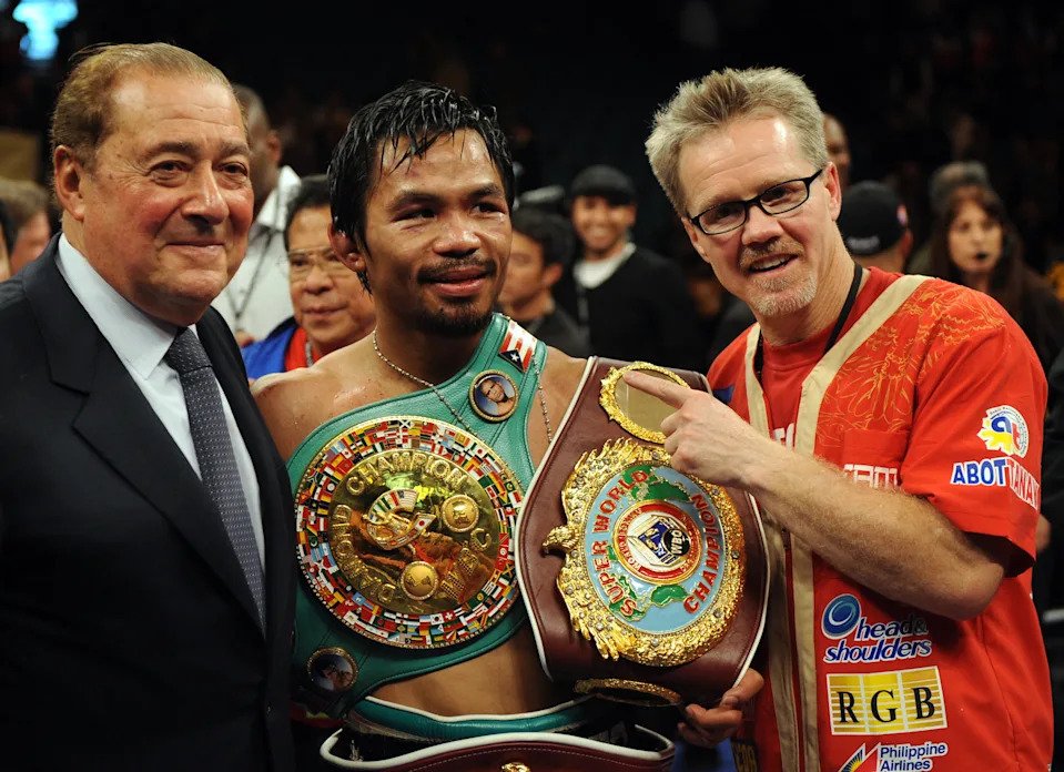 Manny Pacquiao of the Philippines (C) poses for a photo with promoter Bob Arum (L) and trainer Freddie Roach after defeating Miguel Cotto of Puerto Rico in a WBO welterweight title fight at the MGM Grand Garden Arena in Las Vegas, Nevada November 14, 2009.  AFP PHOTO / GABRIEL BOUYS (Photo credit should read GABRIEL BOUYS/AFP via Getty Images)