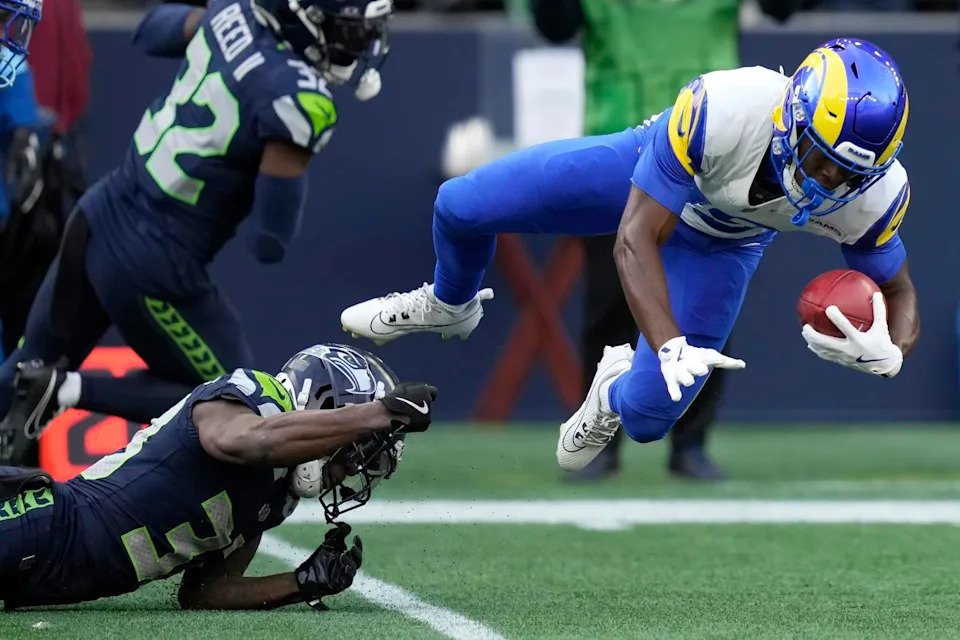 The Rams' Xavier Smith is tackled by the Seahawks' Dee Williams during a punt return.