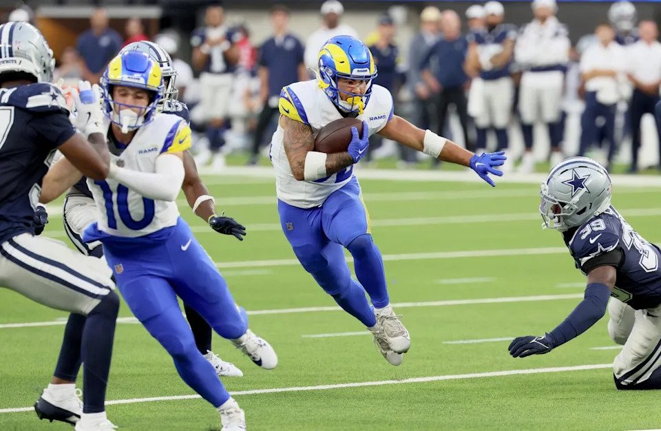 Rams running back Cody Schrader carries the all past Cowboys defensive back Mike Smith during a preseason game.