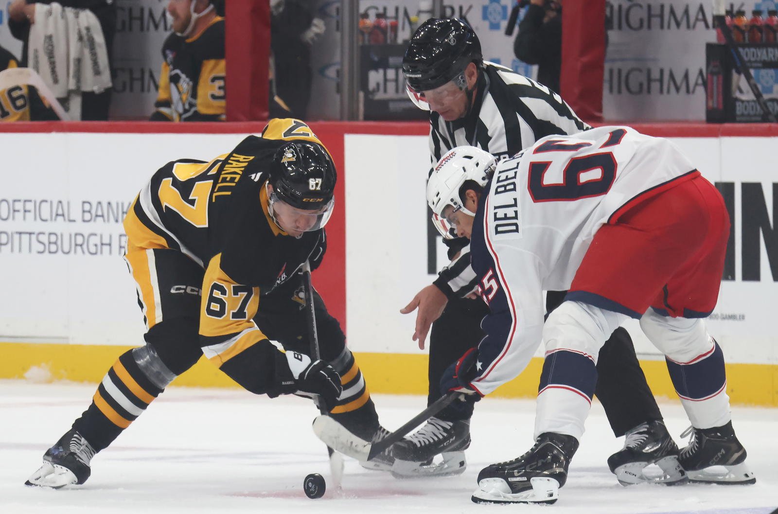 Sep 27, 2025; Pittsburgh, Pennsylvania, USA; Pittsburgh Penguins right wing Rickard Rakell (67) takes a face-off against Columbus Blue Jackets center Luca Del Bel Belluz (65) during the first period at PPG Paints Arena. Mandatory Credit: Charles LeClaire-Imagn Images