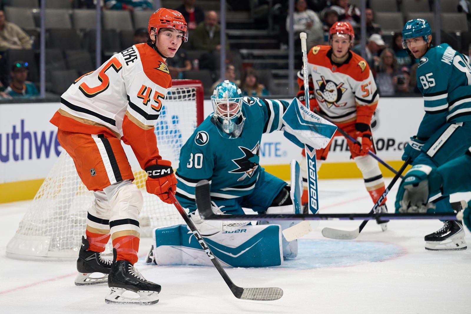 Oct 1, 2025; San Jose, California, USA; Anaheim Ducks right wings Beckett Sennecke (45) and Yegor Sidorov (57) watch the play against San Jose Sharks goaltender Yaroslav Askarov (30) and defenseman Shakir Mukhamadullin (85) during the first period at SAP Center at San Jose. Mandatory Credit: Robert Edwards-Imagn Images