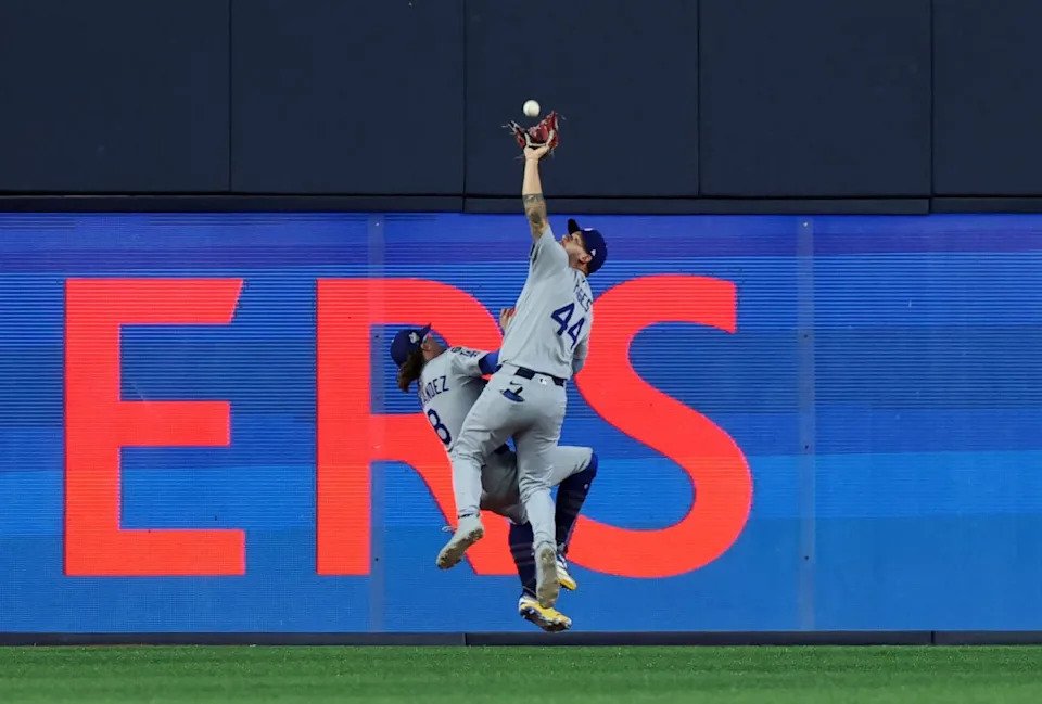 Center fielder Andy Pages (44) reaches to catch the fly ball in game seven.