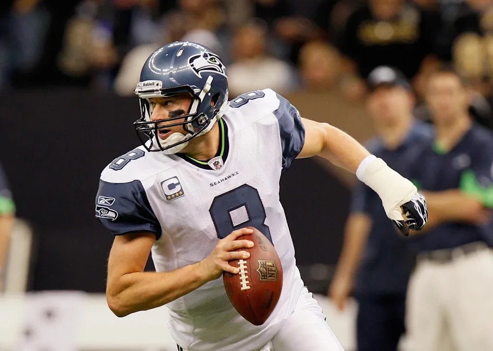 Seattle quarterback Matt Hasselbeck holds the ball in one hand while the other is wrapped in a cast during a game