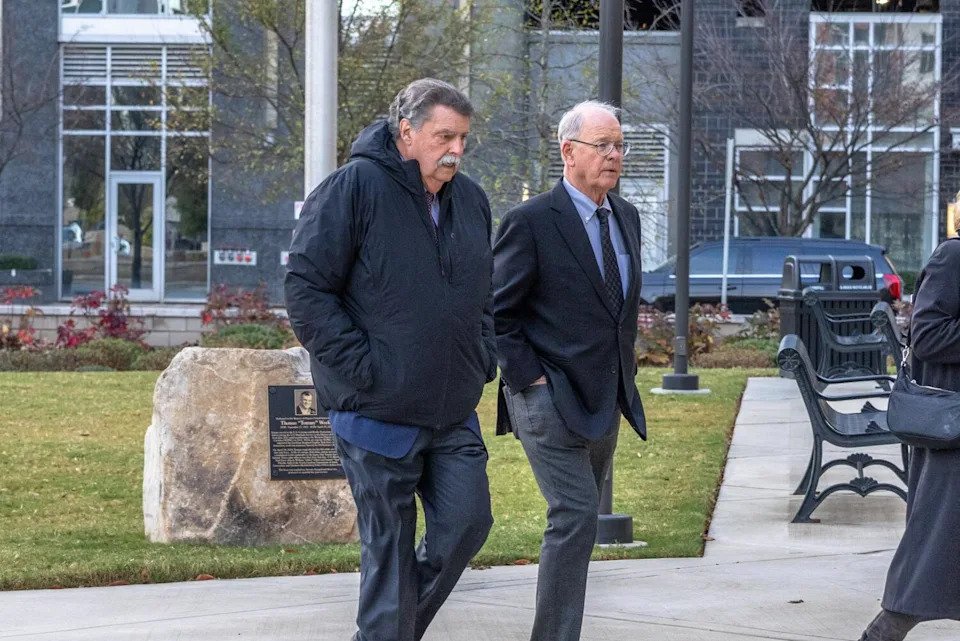 Jim France, right, walks with Mike Helton, both with hands in their pockets, outside a government building