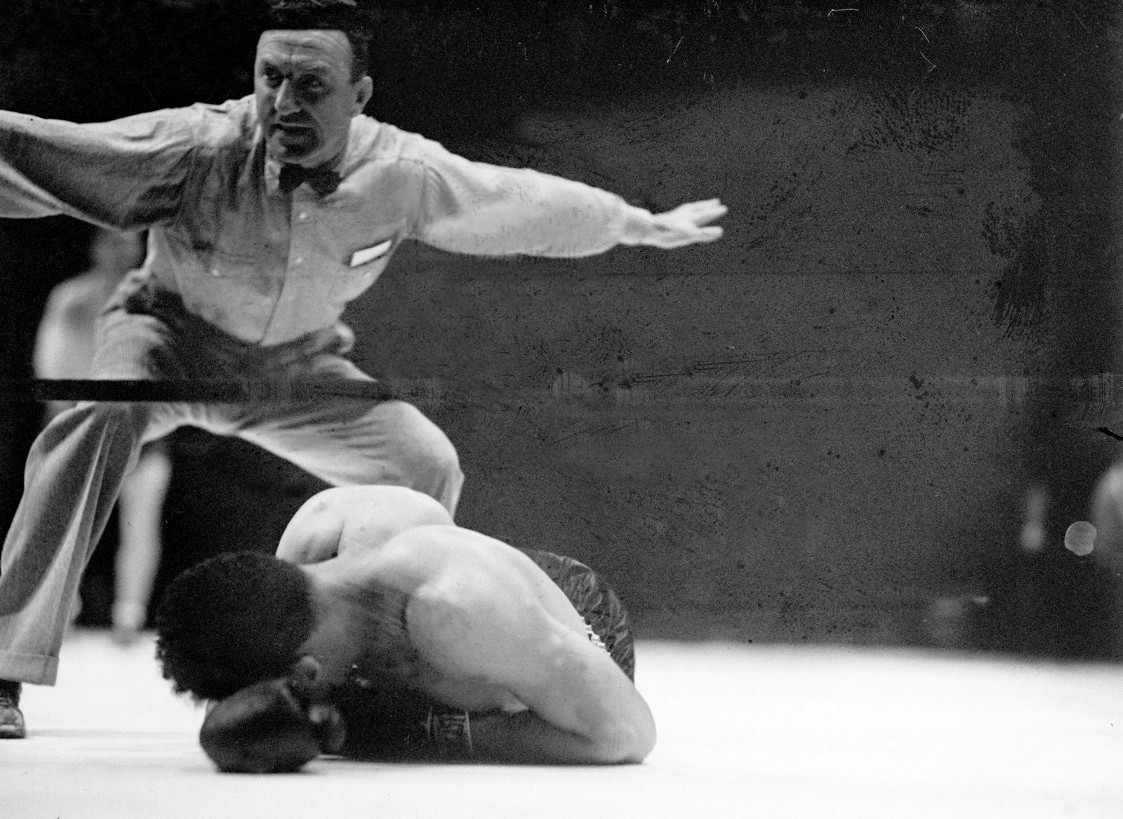 UNITED STATES - JUNE 19:  Joe Louis versus Max Schmeling I, Louis lies face downward on the canvas in the 12th round, knocked senseless by Schmeling's right to the jaw. The loud roar of 70,000, people makes Referee Arthur Donovan's voice inaudible as he tolls off the count over the fallen gladiator.  (Photo by NY Daily News Archive via Getty Images)
