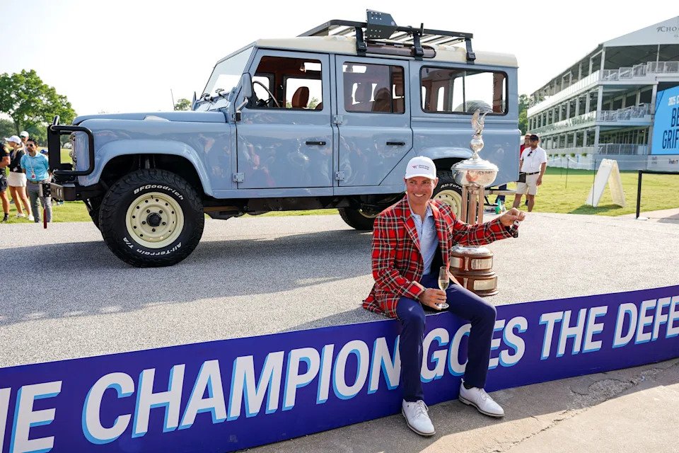 Ben Griffin poses with the winner's trophy and 1992 Schwab Defender following the final round of the Charles Schwab Challenge.