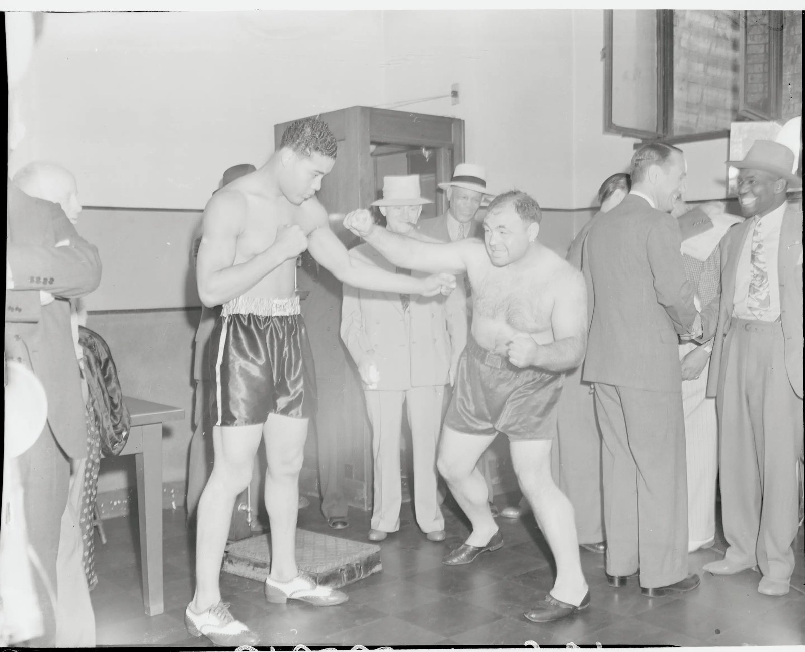 (Original Caption) A Little Like David and Goliath. New York: Joe Louis, heavyweight titleholder looms like a skyscraper over the rotund challenging Tony Galento after they had weighed in at the boxing commission office. Louis has height and reach very much in his favor but Tony outweighed the champion 233 3/4 to 200 3/4 lbs.