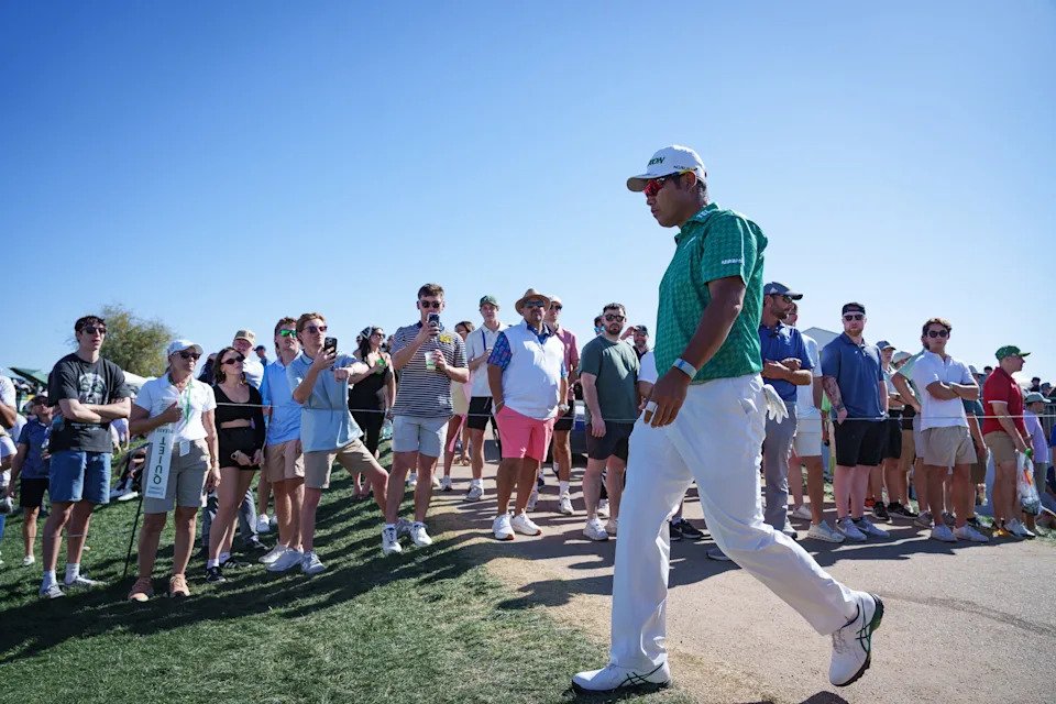 A crowd of people cheer for Hideki Matsuyama as he walks toward the tee box at the 7th hole at the WM Phoenix Open at TPC Scottsdale on Feb. 7, 2026.