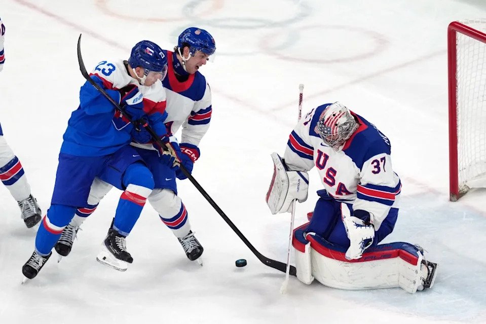 Slovakia’s Adam Liska (23) battles with United States’ Brock Faber, center, for the puck in front of United States goalkeeper Connor Hellebuyck (37) during the third period of a men’s ice hockey semifinal game at the 2026 Winter Olympics in Milan, Italy, Friday, Feb. 20, 2026. AP