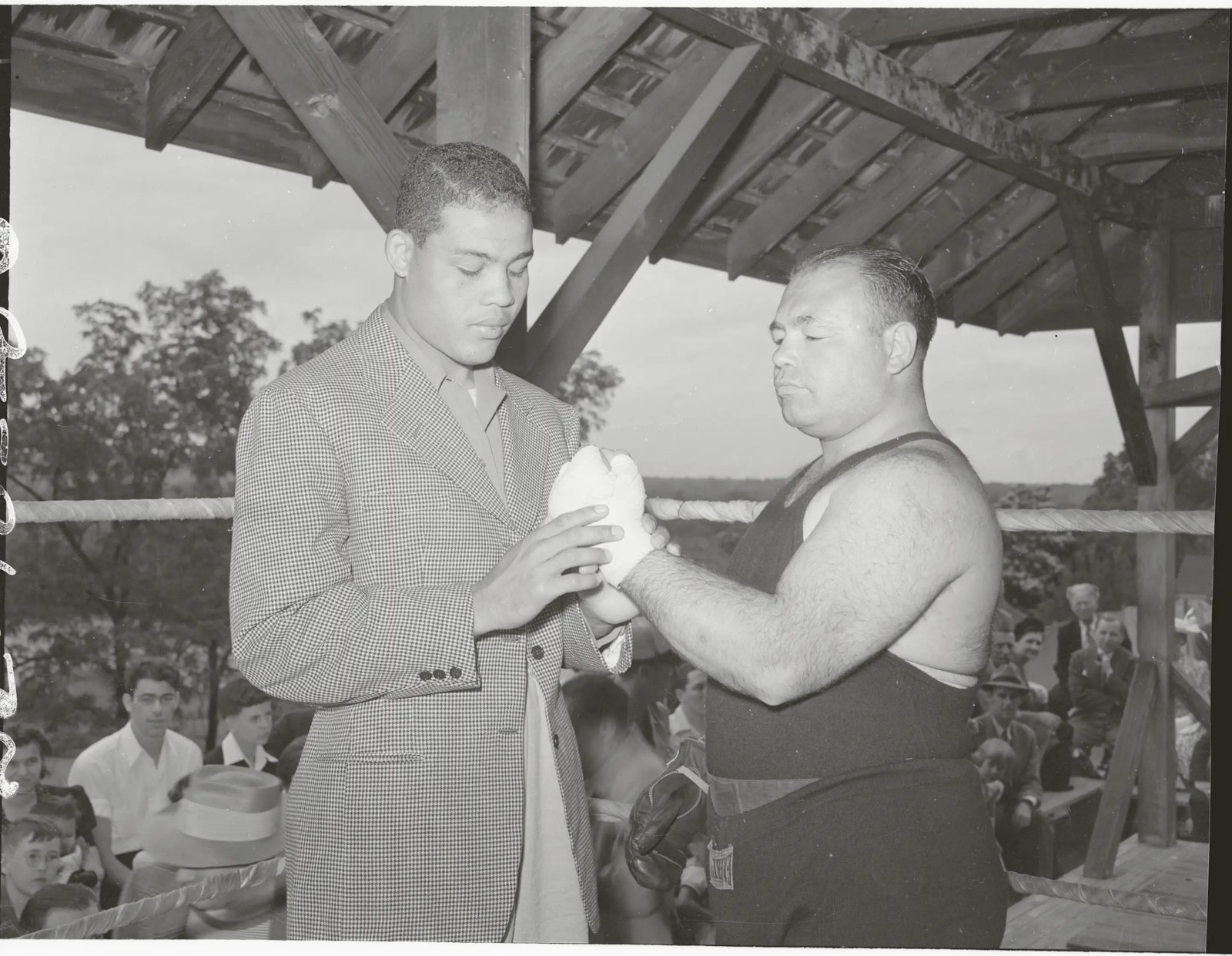 (Original Caption) Artist O.K's Galento. Summit, N.J.: Heavyweight champion Joe Louis, right, takes a look at Tony Galento's powerful right hand at Galento's Summit, N.J., training camp where the New Jersey barkeeper, whom Louis once flattened, is getting ready for his bout with former heavyweight champ Max Baer, of California. Louis said Galento looked 