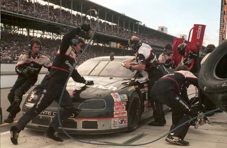 Seven-time Winston Cup Champion Dale Earnhardt's crew service his car during his last pit stop before winning the Brickyard 400.