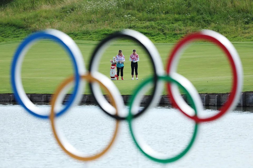 Brooke M. Henderson of Team Canada looks across the 15th hole alongside her caddie, Brittany Henderson through the Olympic rings during Day Two of the Women's Individual Stroke Play on day thirteen of the Olympic Games Paris 2024 at Le Golf National on August 08, 2024 in Paris, France. (Photo by Kevin C. Cox/Getty Images)