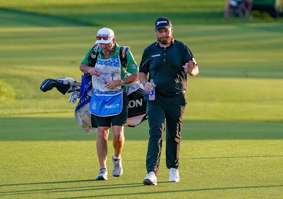 Shane Lowry acknowledges the crowd as he walks up the 18th fairway with his caddie Darren Reynolds during the final round of the Cognizant Classic in the Palm Beaches at PGA National Resort & Spa on Sunday, March 1, 2026, in Palm Beach Gardens, FL.