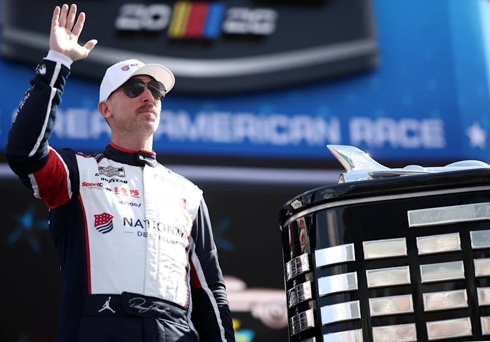 Denny Hamlin waves to the crowd during driver introductions at the Daytona 500. (Photo by James Gilbert/Getty Images)