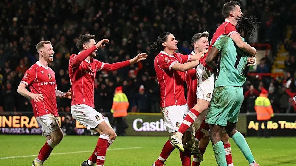 Wrexham players celebrate with Arthur Oknonkwo