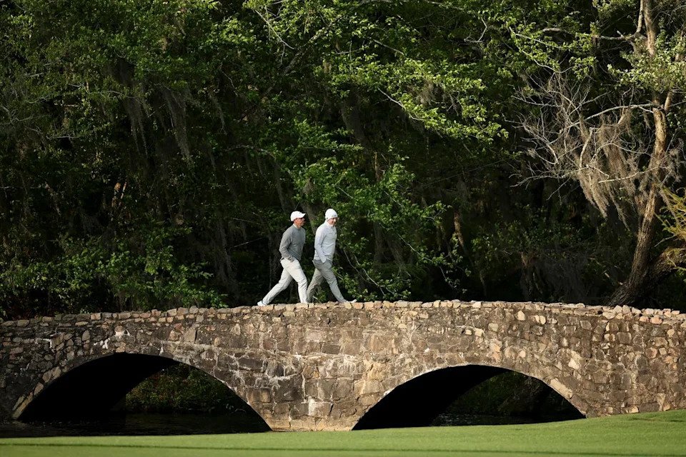 Rory McIlroy and Matt Fitzpatrick walk over the Nelson Bridge on the 13th hole during practice (Getty)
