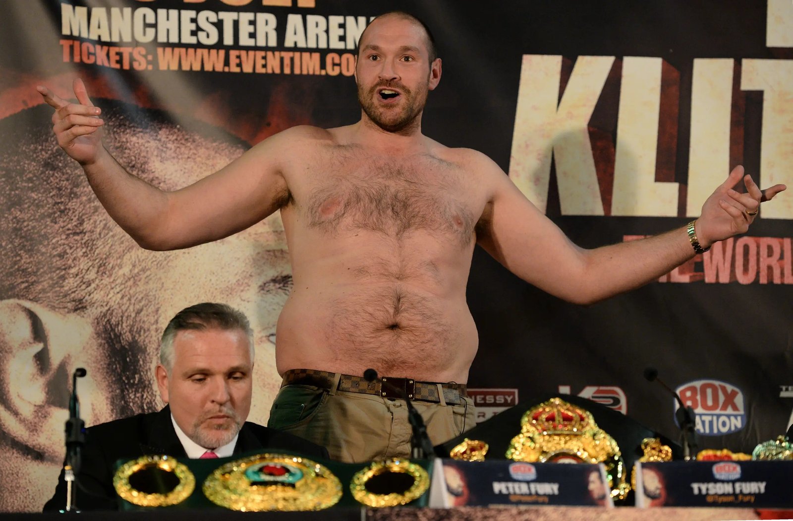 British heavyweight boxer Tyson Fury (C) gestures after removing his t-shirt during a press conference to publicise his forthcoming world heavyweight title fight against Ukranian heavyweight Wladimir Klitschko, at the Manchester Arena in Manchester, north-west England on April 27, 2016.Wladimir Klitschko has insisted he was