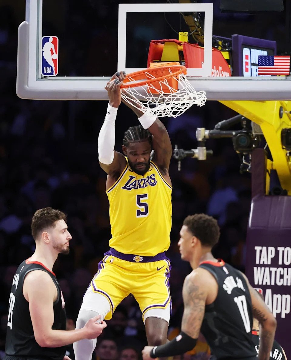 Lakers center Deandre Ayton dunks between two Rocket defenders in Game 1.