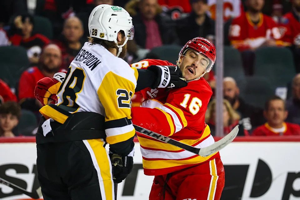 Jan 21, 2026; Calgary, Alberta, CAN; Calgary Flames center Morgan Frost (16) and Pittsburgh Penguins defenseman Parker Wotherspoon (28) get into a scrum during the second period at Scotiabank Saddledome. Mandatory Credit: Sergei Belski-Imagn Images