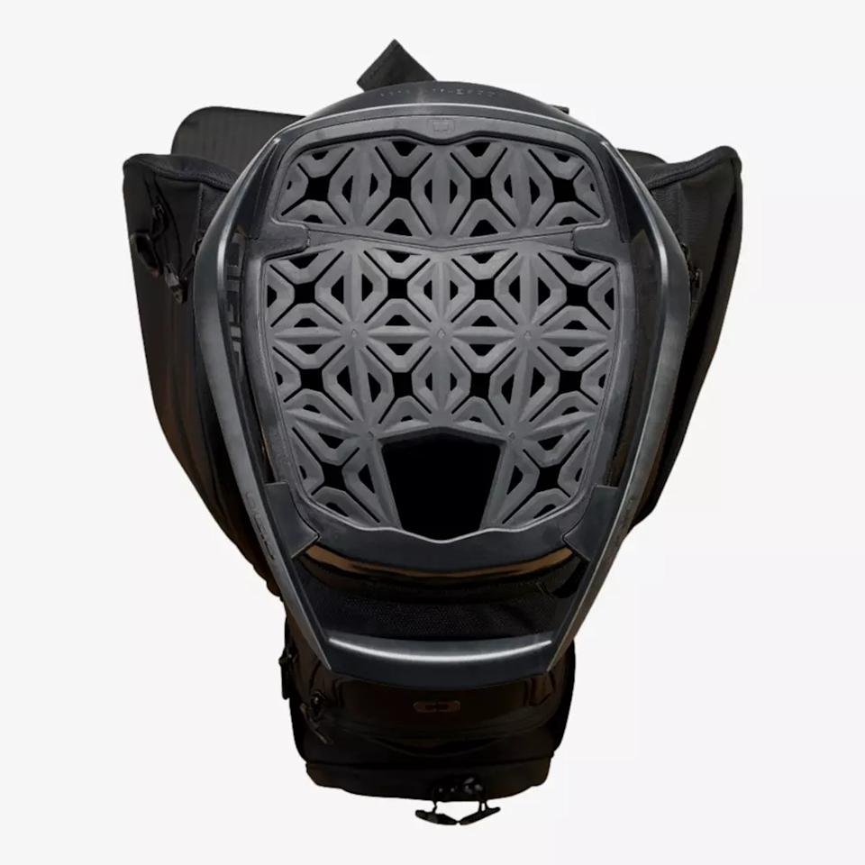 A black backpack with the top open, revealing a geometric, lattice-patterned back panel for ventilation and support—similar to the innovative designs seen in the best golf bags 2026. Interlocking shapes and an open area at the bottom center enhance airflow.