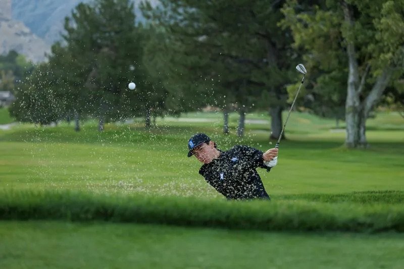 BYU freshman Kihei Akina blasts out of a bunker during photo day, Sept. 2, 2025. | Jaren Wilkey, BYU Photo