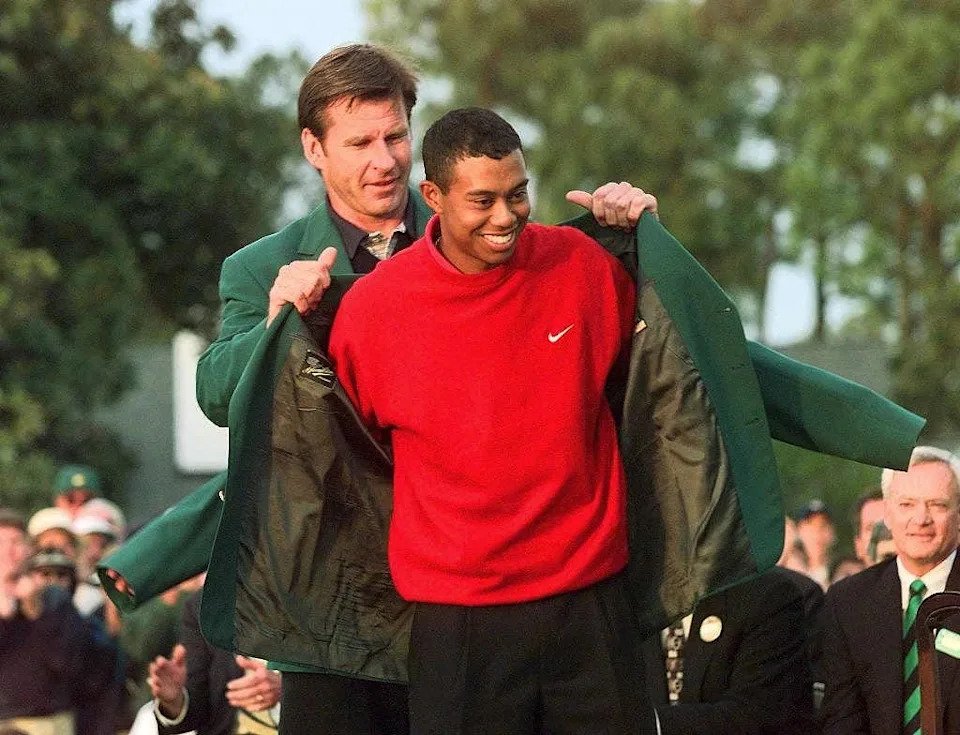 Tiger Woods (R) receives the Masters green jacket for winning the 1997 Masters Tournament 13 April from 1996 winner Nick Faldo at Augusta National Golf Club in Georgia. Woods won the tournament with a record eighteen-under-par.